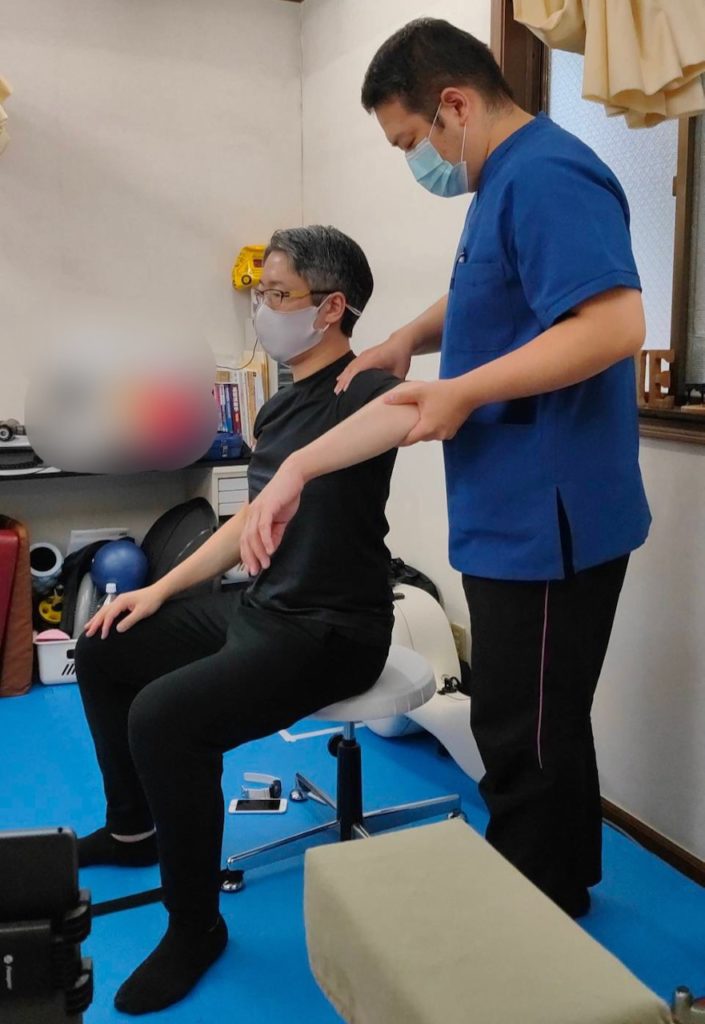 チェロ奏者の左肩の痛みを感じていた人に対して左肩の動きを確認している場面です。