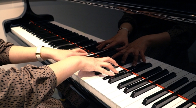 ピアノ演奏中の写真です。オクターブを弾く状態に近いくらい指を開いて打鍵しています。