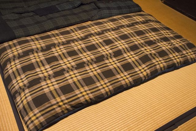 畳の上にひかれた敷布団。マットレスもないため硬い状態であり、ヤセ型の人にとっては腰痛の原因になります。