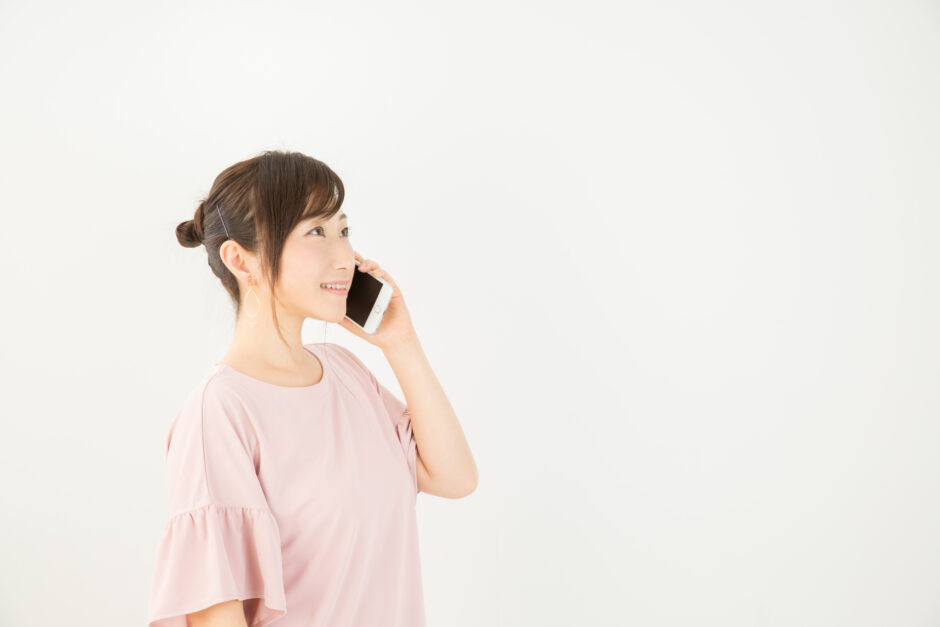 スマートフォンにて整体の予約を電話でしている女性