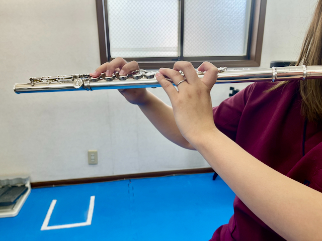 フルート奏者の指の配置です。他の楽器に比べ左手が特殊な持ち方になっています。左人差し指：第3関節(MP関節)を伸展させた状態で楽器を支え、第1関節(DIP関節)、第2関節(PIP関節)を曲げてキィを押さえる
左中指：第1関節(DIP関節)・第2関節(PIP関節)曲げた状態で第3関節(MP関節)をキィを押さえる
左薬指：第2関節(PIP関節)を軽く曲げ、第3関節(MP関節)でキィを押さえる
左小指：第1関節(DIP関節)・第2関節(PIP関節)は伸ばしたまま、第3関節(MP関節)でキィを押さえる