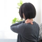 頸肩腕症候群での痛みに悩む女性。