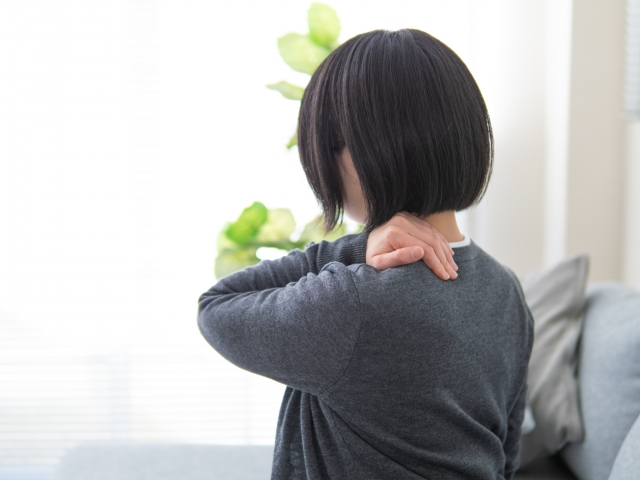 頸肩腕症候群での痛みに悩む女性。