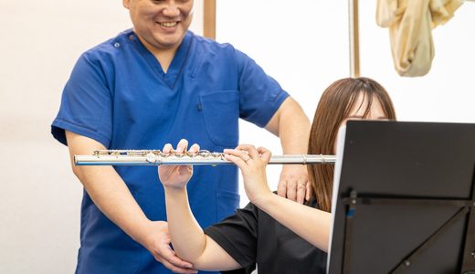 フルート奏者に対して姿勢チェックと身体の使い方について説明している様子