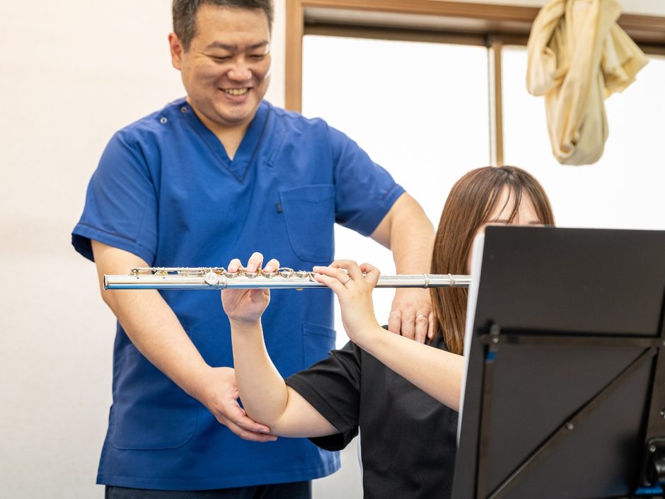 フルート奏者に対して姿勢チェックと身体の使い方について説明している様子